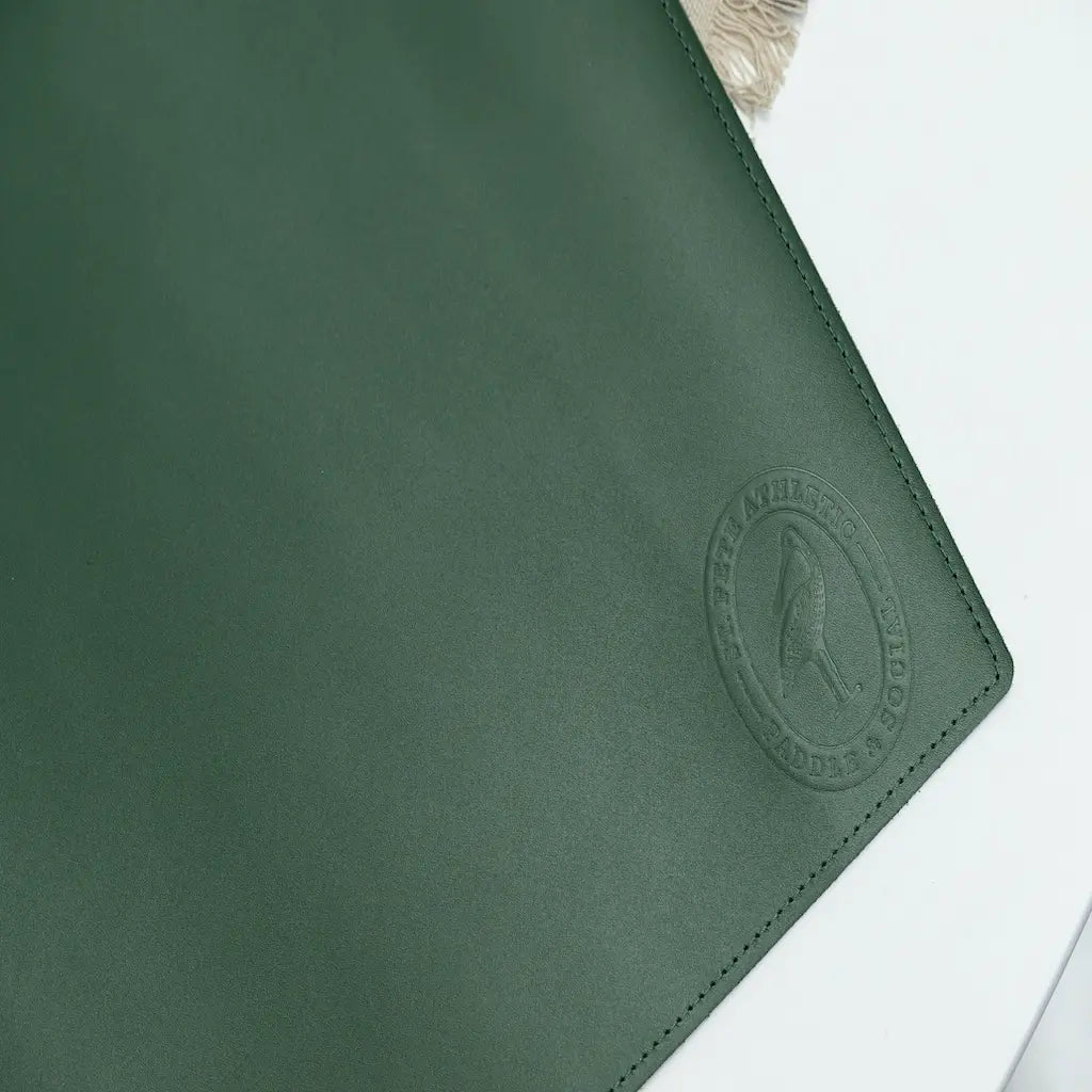 Green leather product with a brand logo on a white surface