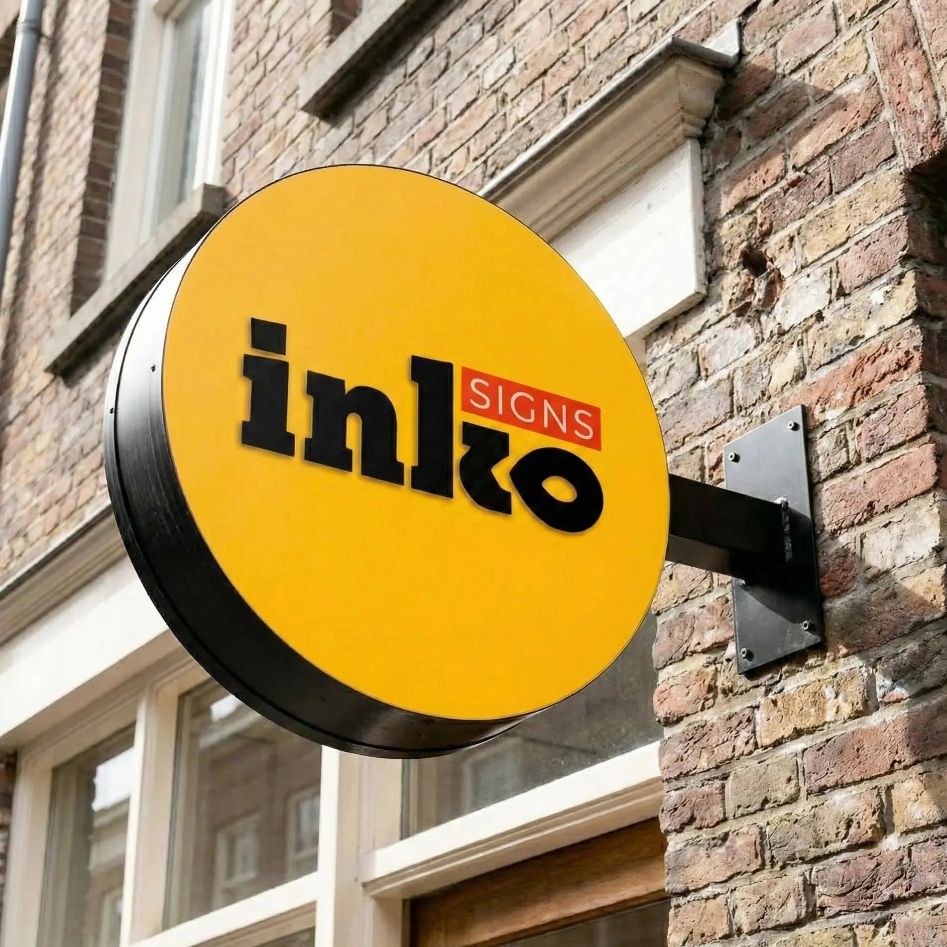 Yellow sign with 'inlo Signs' on a brick building