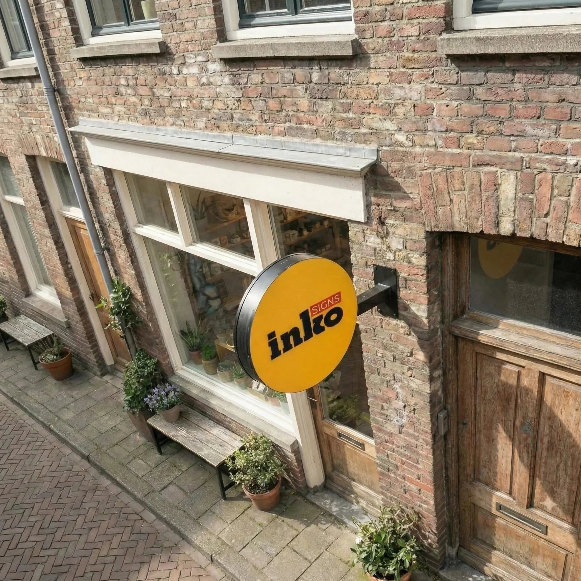 Brick building with a yellow 'inko' sign on a street corner