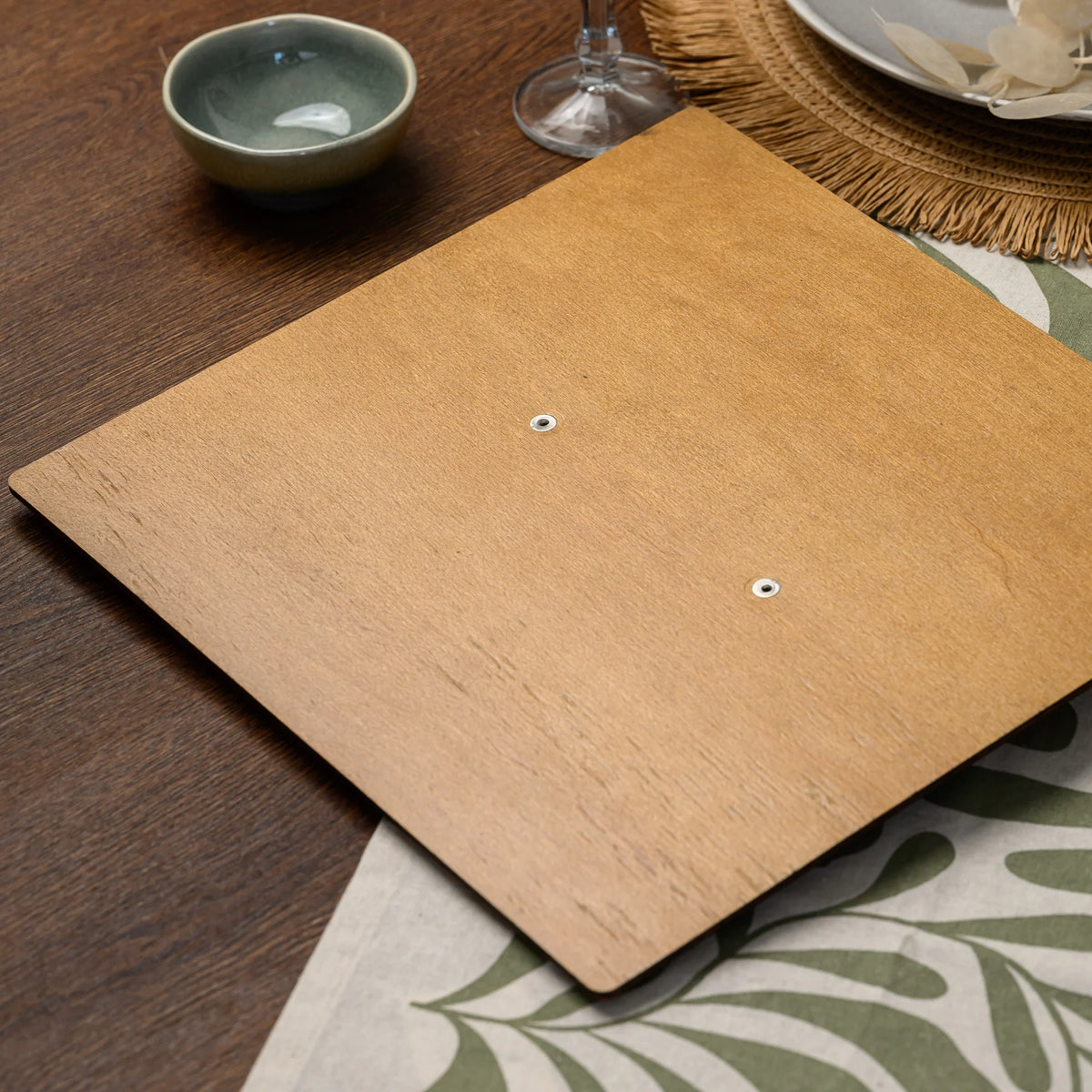 The back of a plywood menu board, showing the two ring-mechanism hardware points seen from behind it