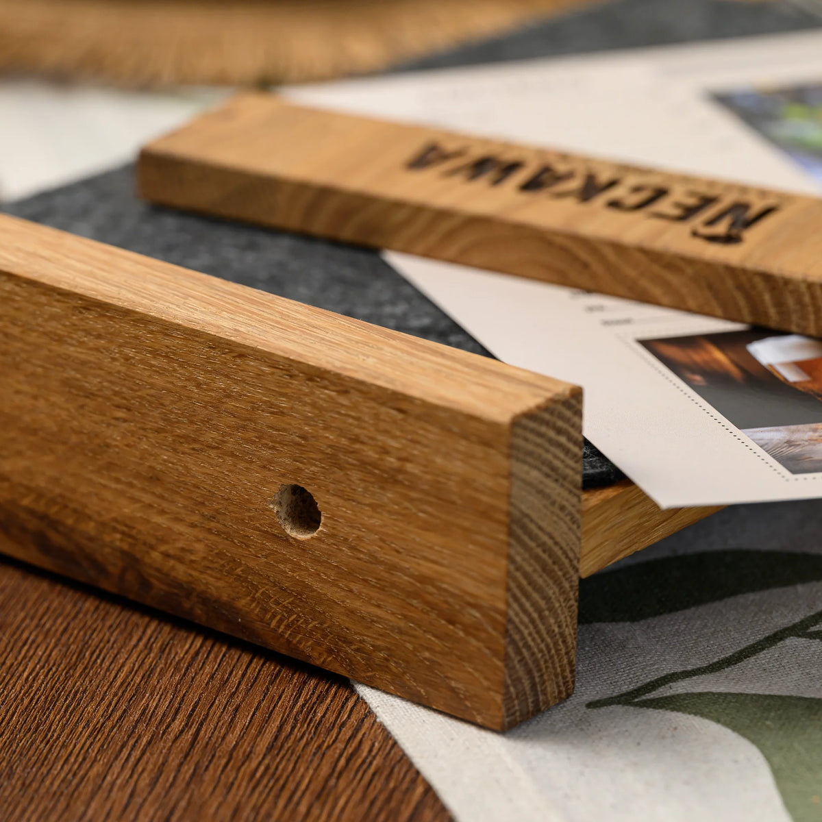 A macro view of a magnet embedded in the end of the engraved oak bar of this table tent, seen closely