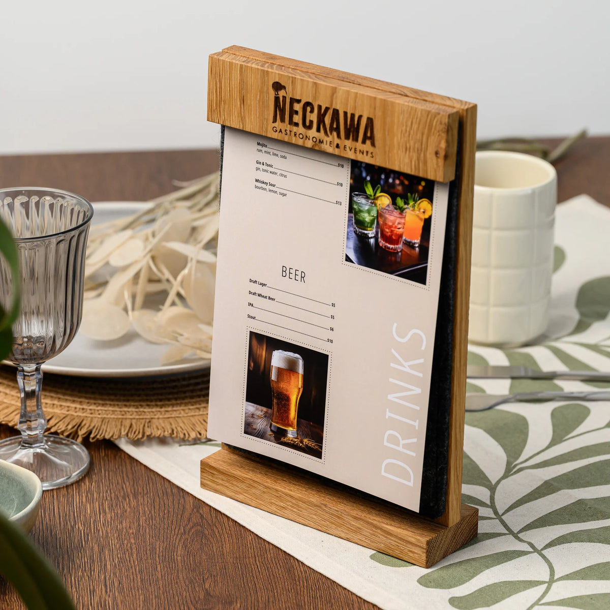 A freestanding table tent with an engraved oak bar and felt panel, displaying a printed drinks menu page