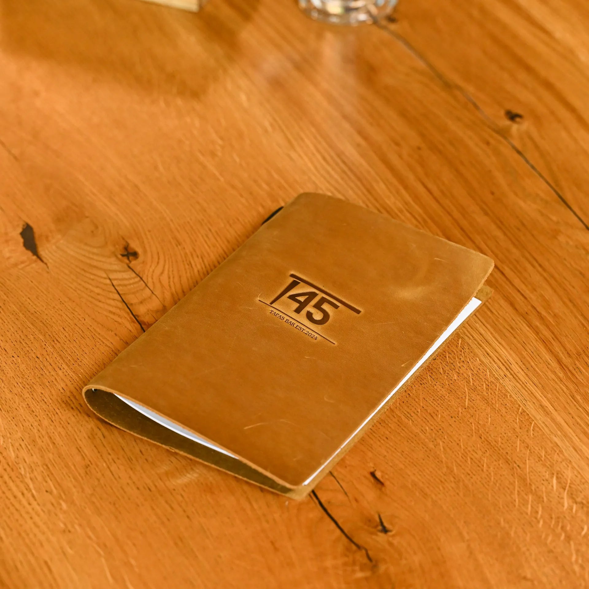 Stylish soft leather menu holder with an elastic band, designed to bind sheets securely. Perfect for restaurants and cafes, with personalization options.