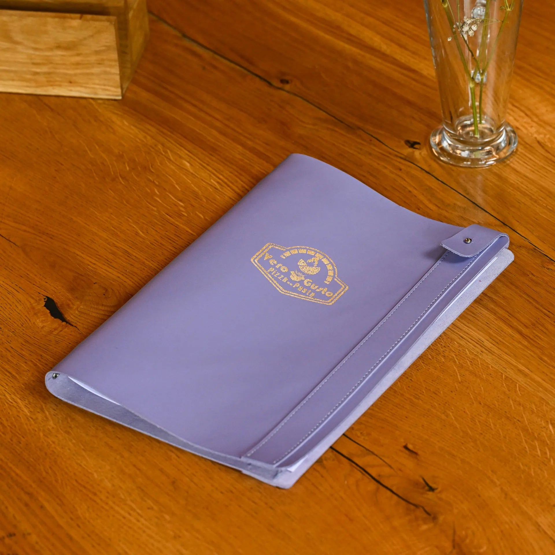 Premium soft leather drink menu holder with elastic strap, designed for changeable half sheets and enhanced with a custom logo embossing.