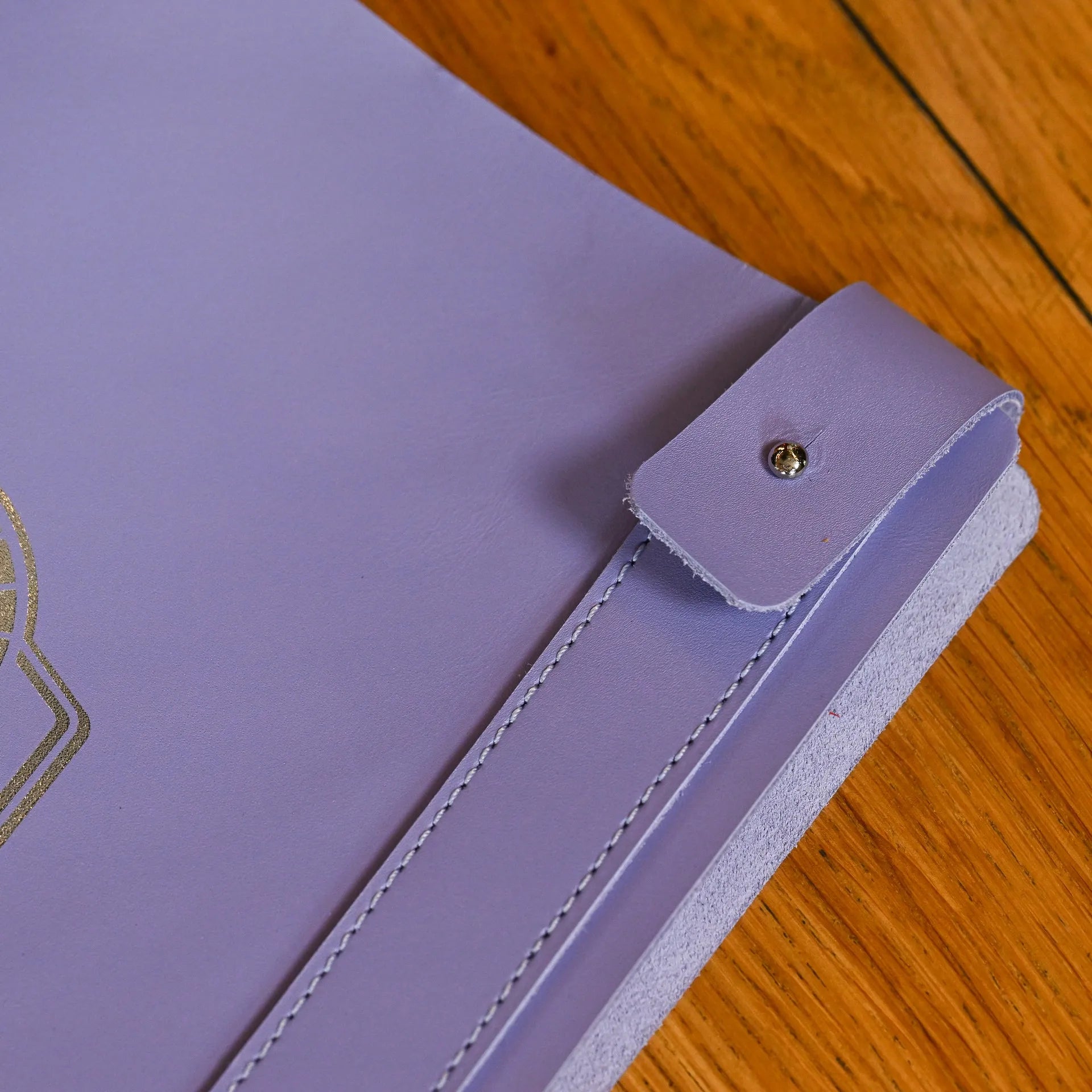 Custom leather menu folder with elastic strap for binding half sheets, featuring an embossed logo and designed for easy updates to drink menus.