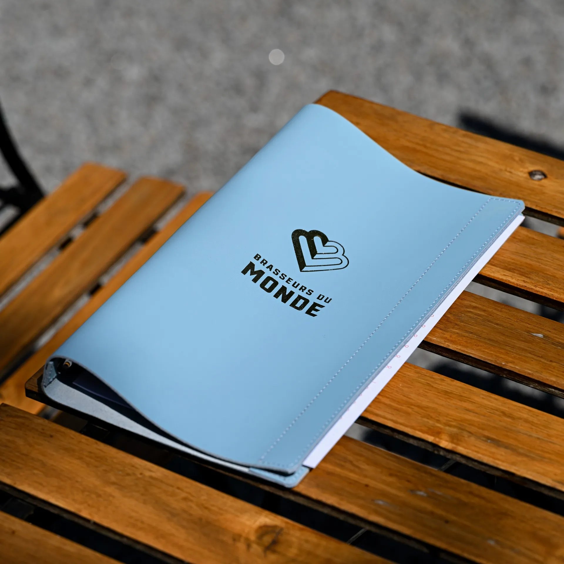 Stylish leather drink menu holder with a ring binder mechanism and embossed logo, offering easy menu updates with a personalized touch.