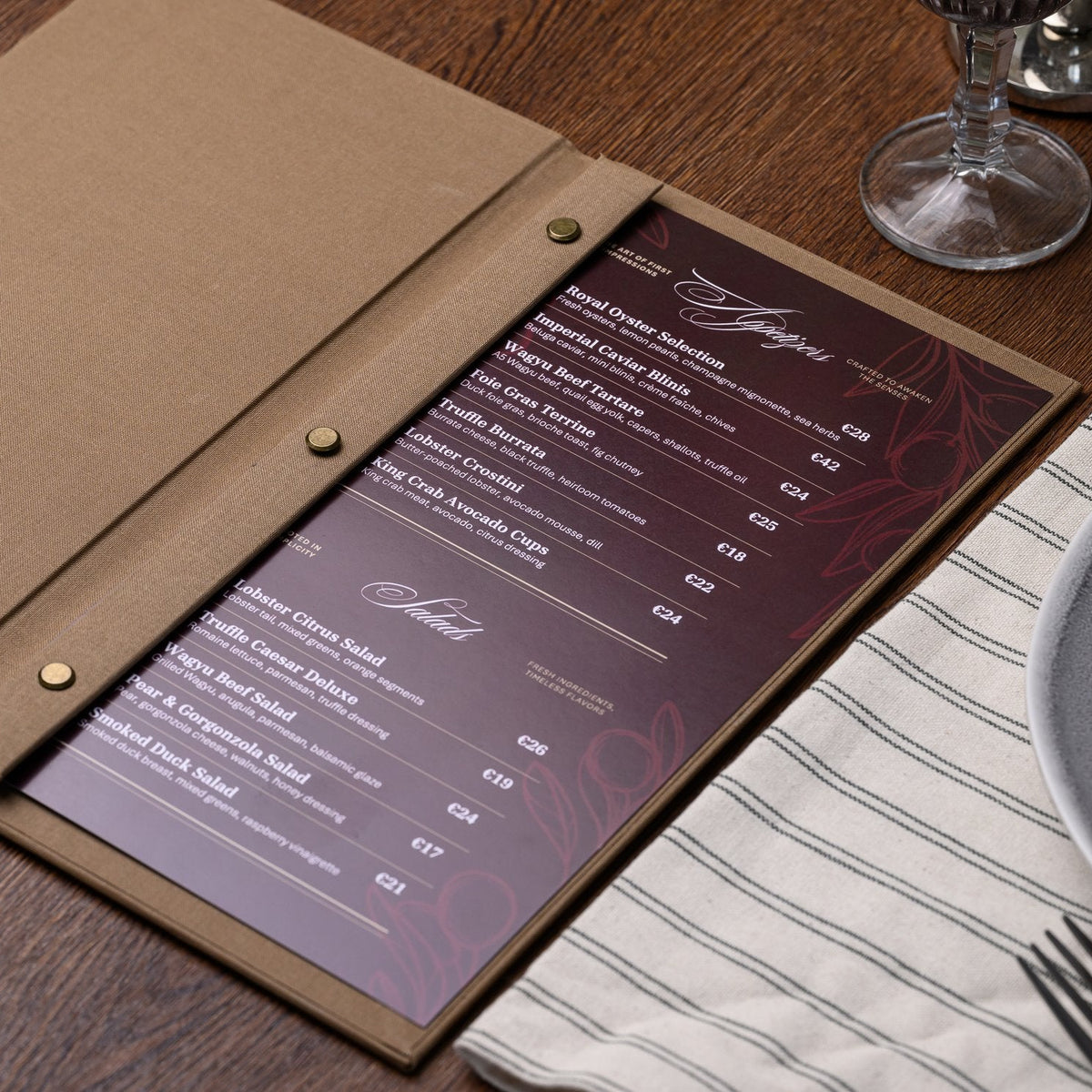 Wide open taupe textile menu folder with a dark page of printed white text and a bar binding rail visible