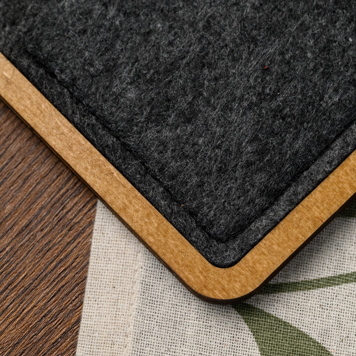 A macro view of the stitched felt pocket corner and wood frame edge on this bill presenter, up close (100)