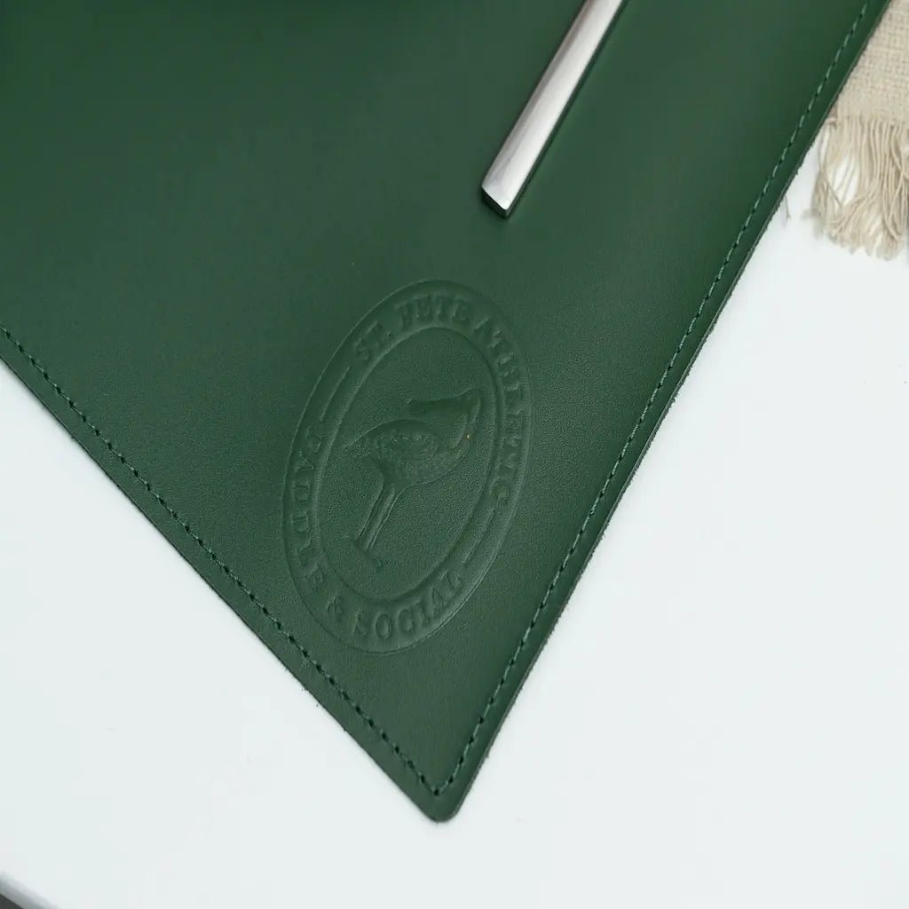Green leather mat with a logo on a white surface