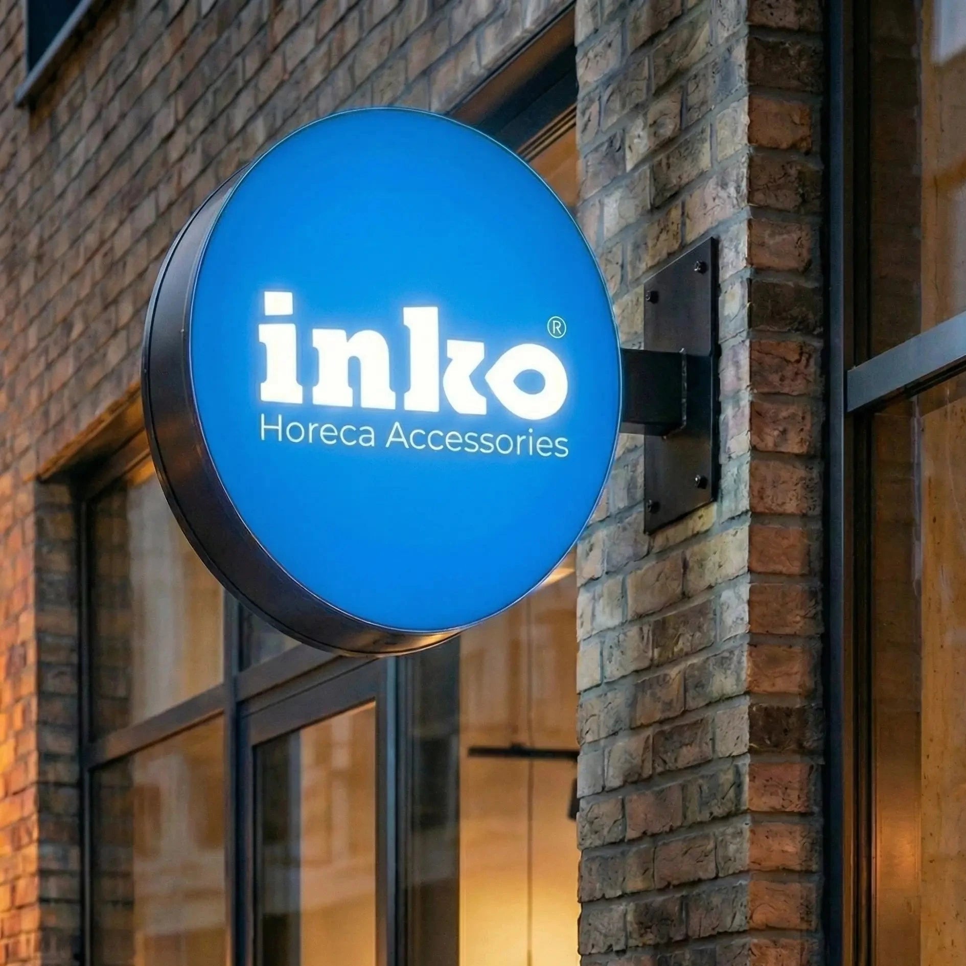 Blue sign with 'inko' logo on a brick building