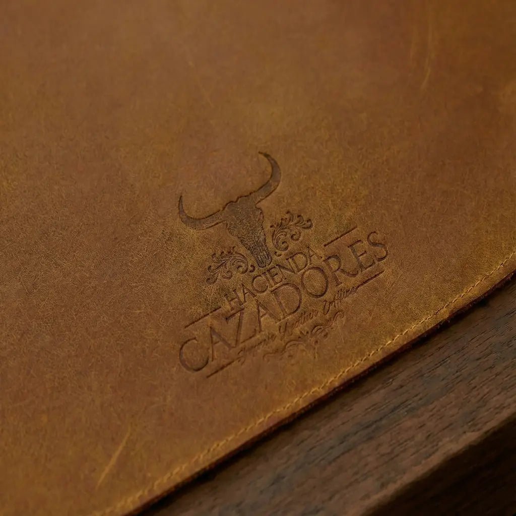 Close-up of a brown leather surface with an embossed logo and text.