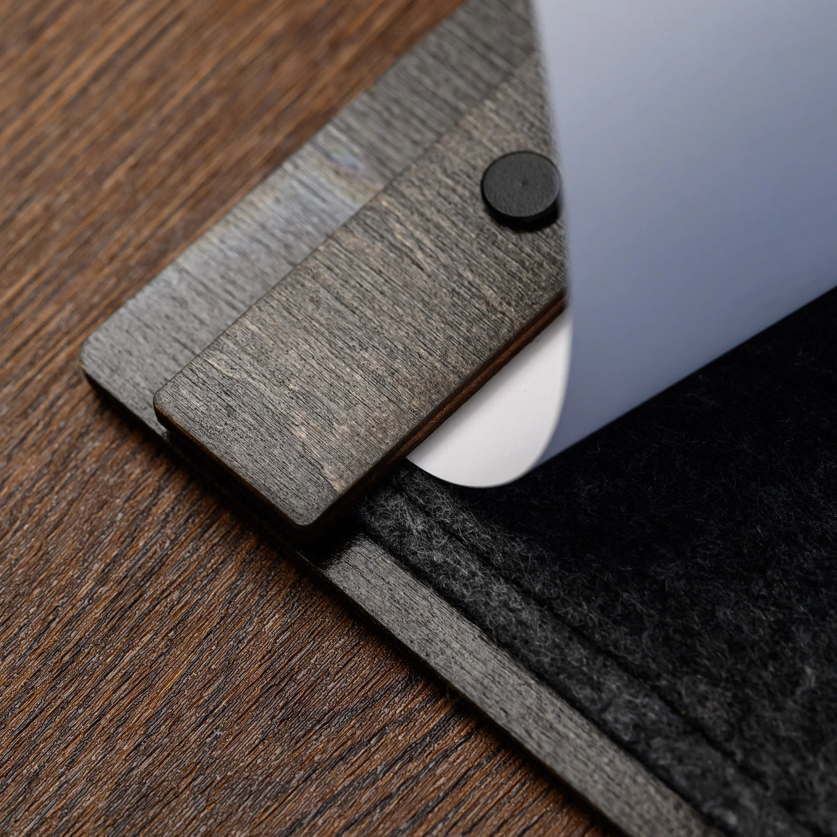 A close-up of the clamp bar and screw detail holding a printed page along the felt menu board edge closely 