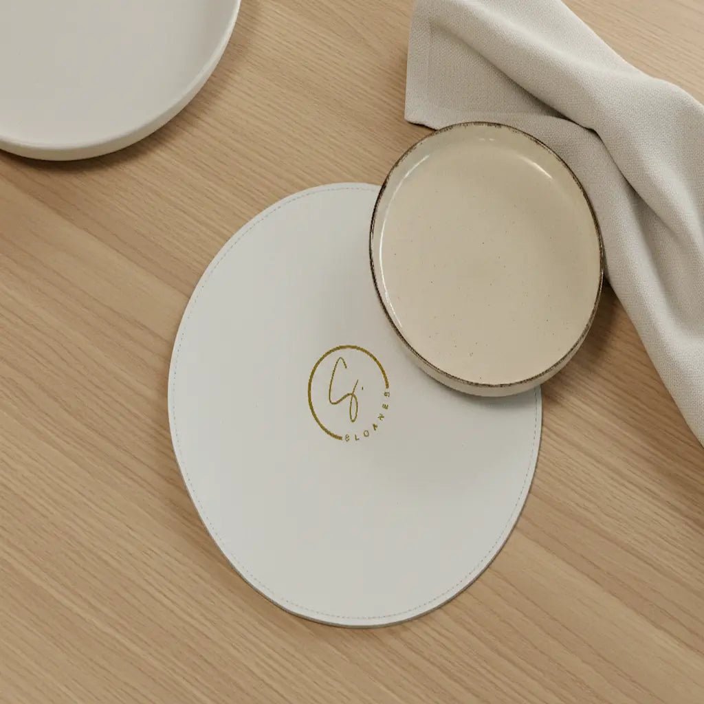 Round ceramic coaster with a logo on a wooden surface