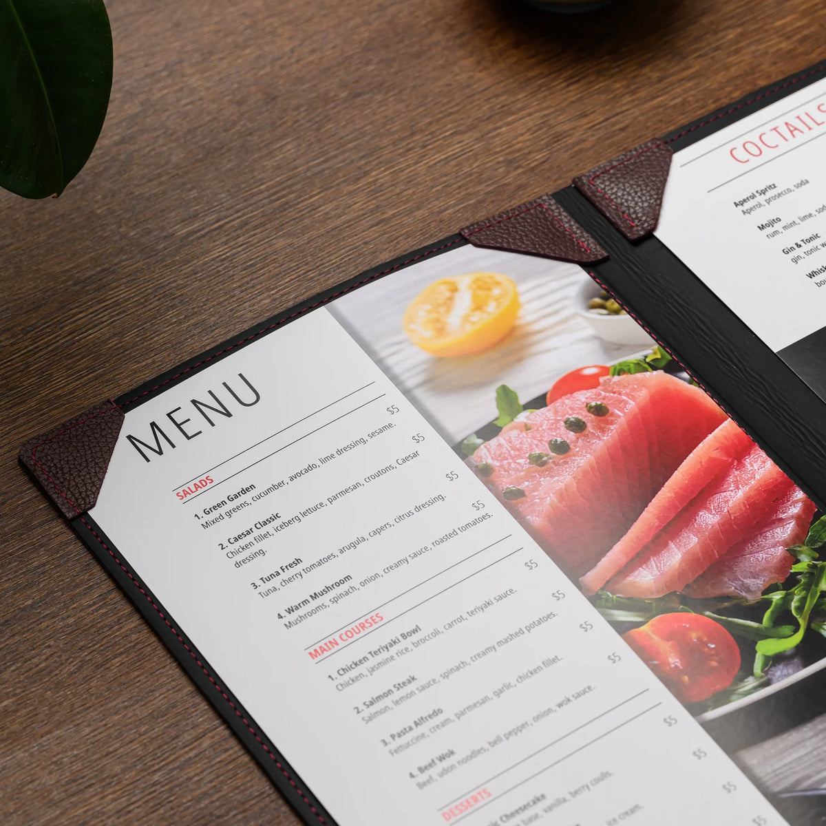 Open menu cover on a wooden table with a food menu sheet secured under bordeaux leather corner mountings