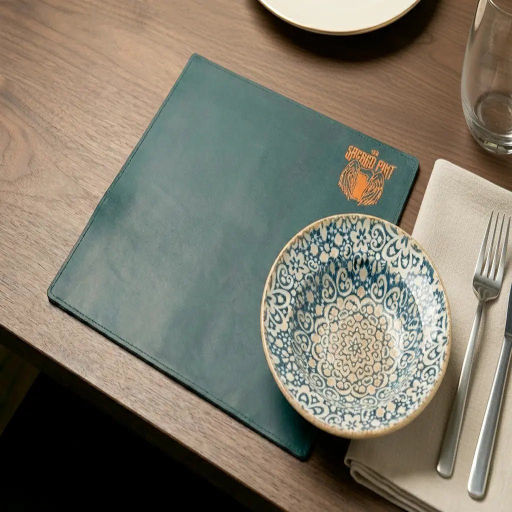 Dinner setting with a decorative plate, fork, knife, and napkin on a wooden table.