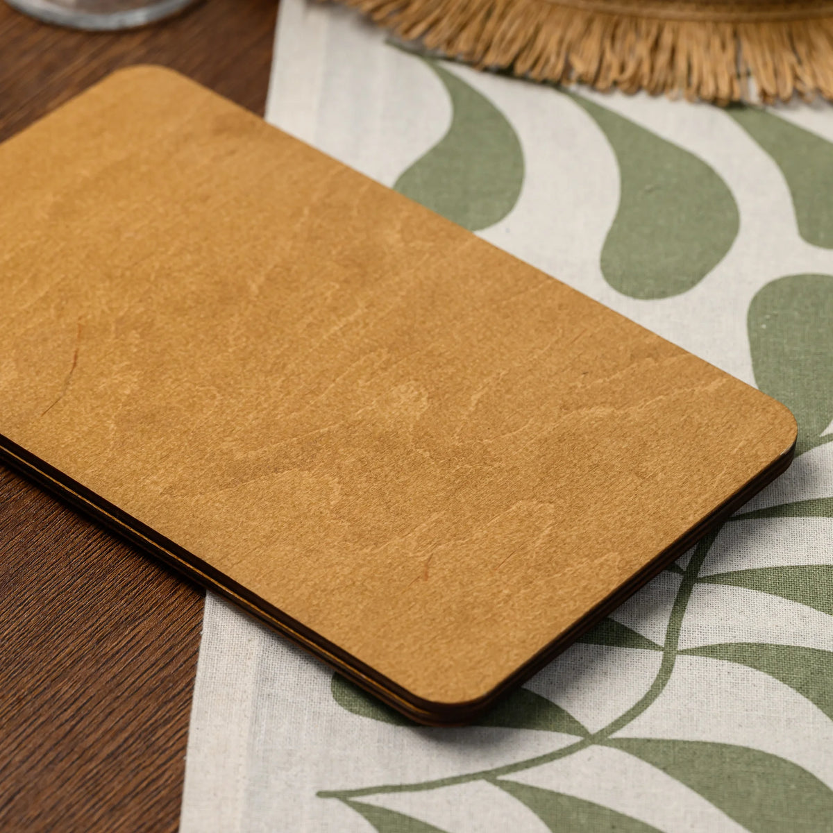 A close-up of the plywood back panel of a bill presenter, showing its rounded corner and layered edge 