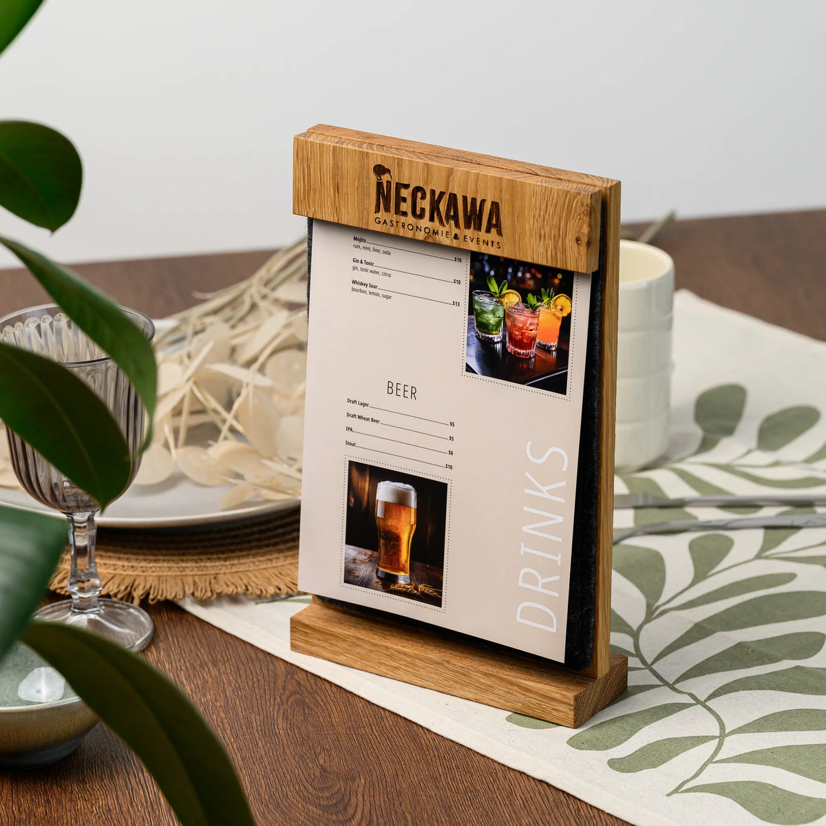 A freestanding table tent standing on a restaurant table, showing the engraved oak bar and menu page 