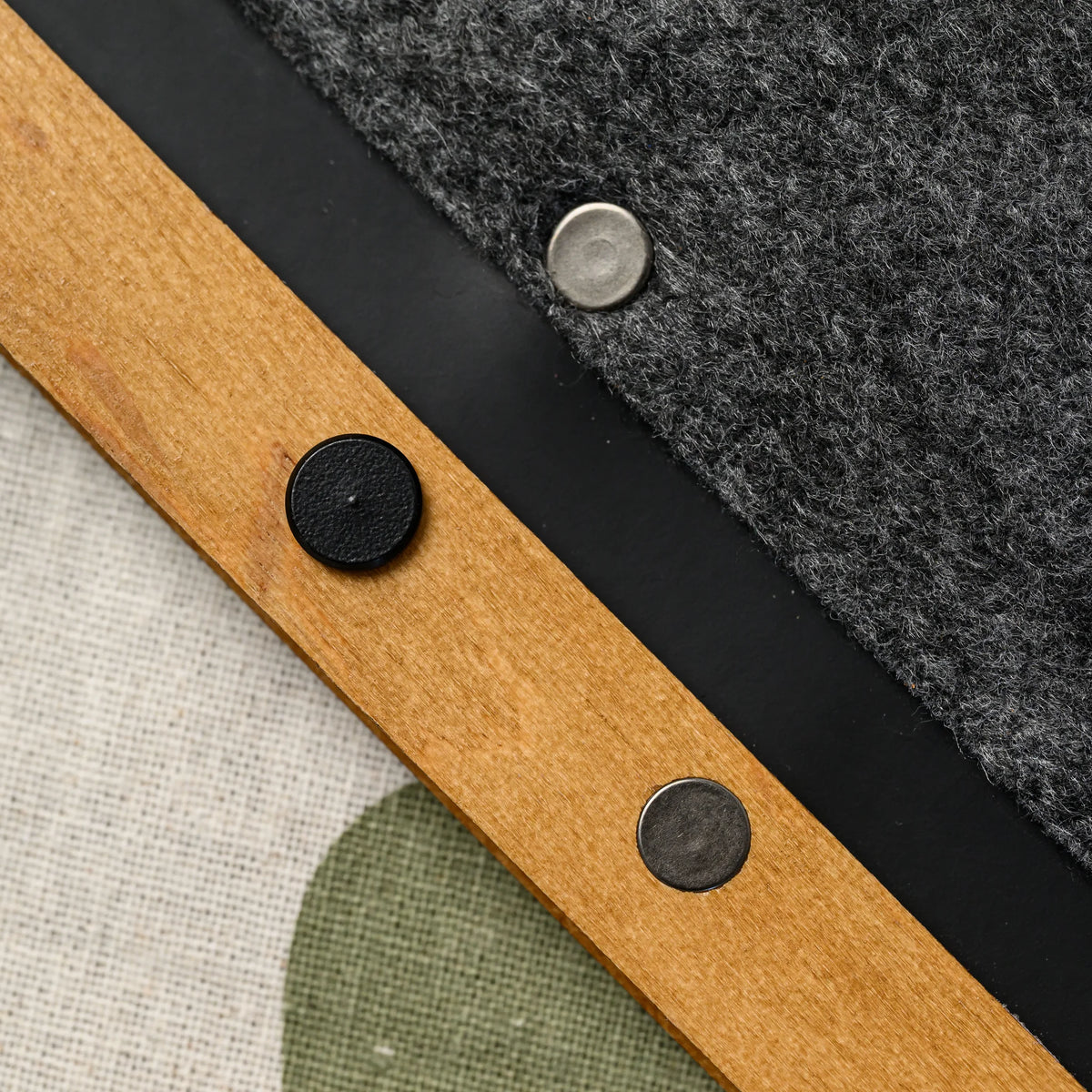 A close-up of a felt menu folder cover peeling back to reveal the layered plywood core edge underneath